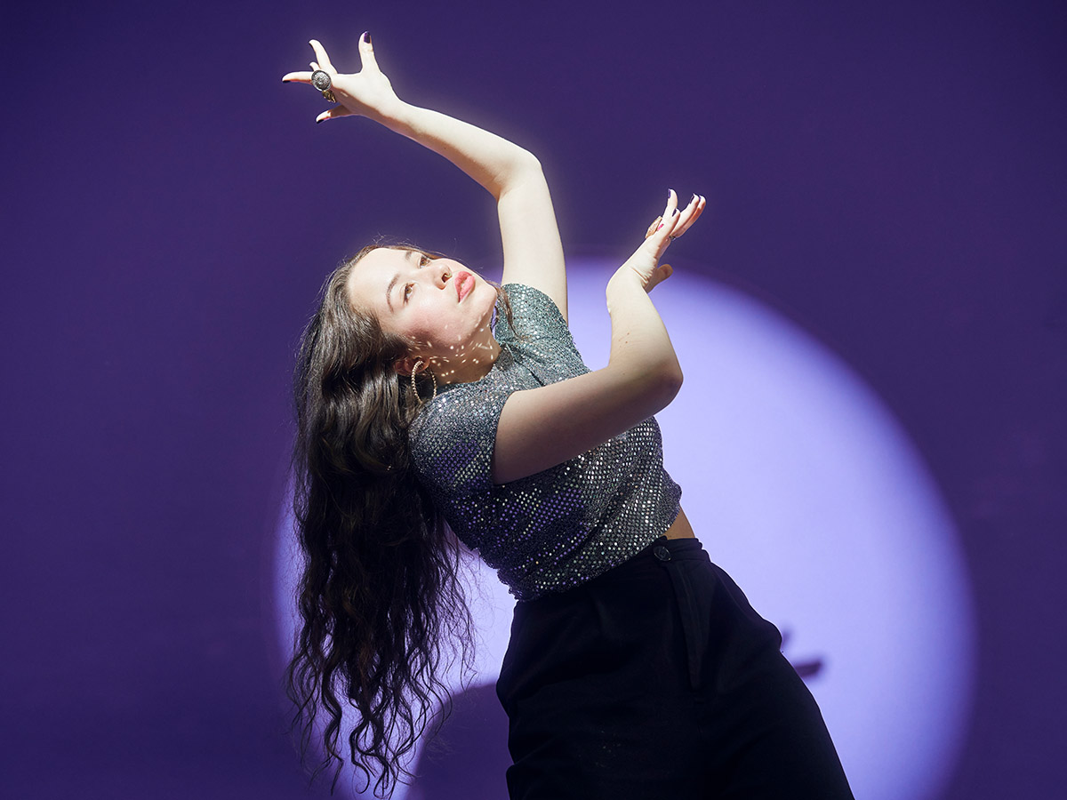 Mädchen tanzt vor violettem Hintergrund
